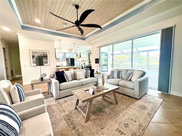 tiled living room with wood ceiling, ceiling fan, a tray ceiling, and crown molding