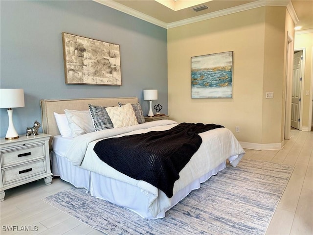 bedroom with ornamental molding and light hardwood / wood-style floors