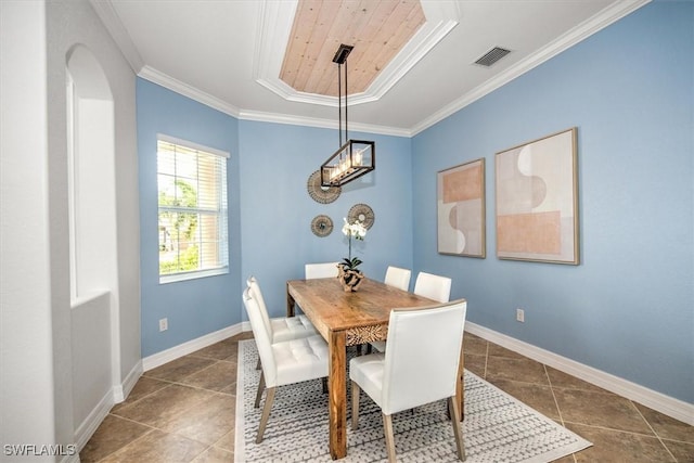 dining room featuring ornamental molding, a raised ceiling, and dark tile patterned floors