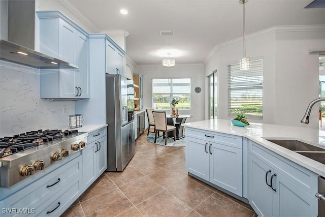 kitchen with pendant lighting, sink, crown molding, appliances with stainless steel finishes, and wall chimney exhaust hood