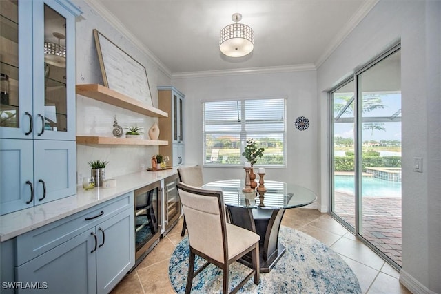 dining space with ornamental molding, beverage cooler, and light tile patterned flooring