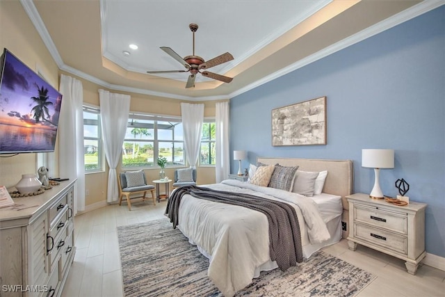 bedroom featuring ceiling fan, ornamental molding, a tray ceiling, and light hardwood / wood-style flooring