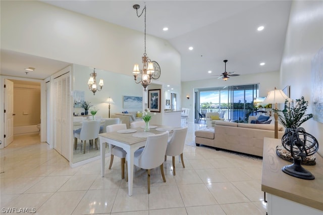 dining space with high vaulted ceiling, ceiling fan with notable chandelier, and light tile patterned floors