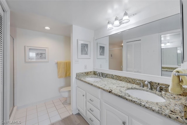 bathroom with vanity, toilet, a shower with door, and tile patterned flooring