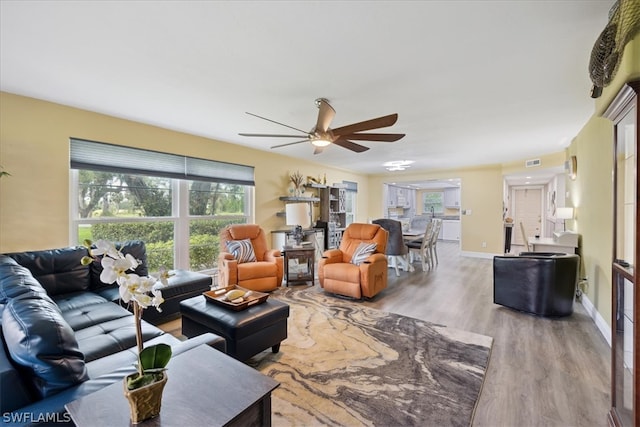 living room with light hardwood / wood-style floors and ceiling fan