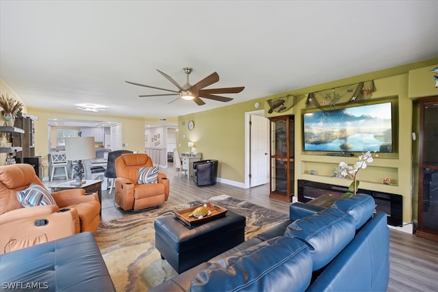 living room featuring wood-type flooring and ceiling fan