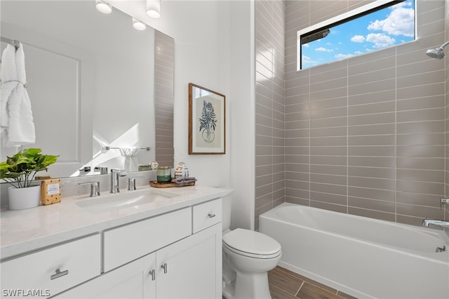 full bathroom with hardwood / wood-style flooring, vanity, toilet, and tiled shower / bath