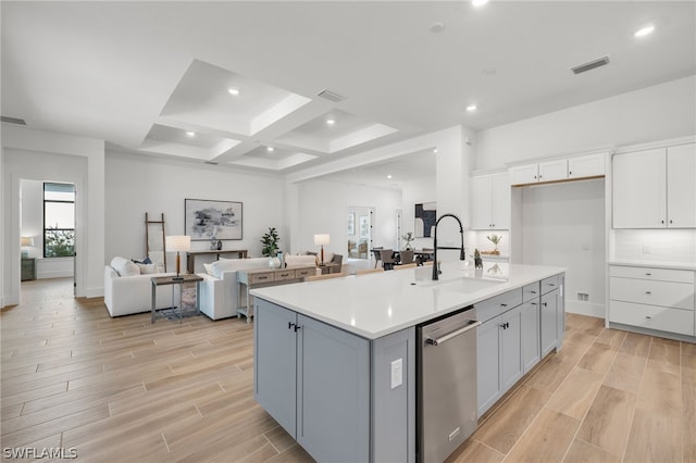 kitchen with dishwasher, sink, coffered ceiling, a kitchen island with sink, and light wood-type flooring