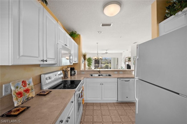 kitchen featuring light countertops, white appliances, a sink, and white cabinets