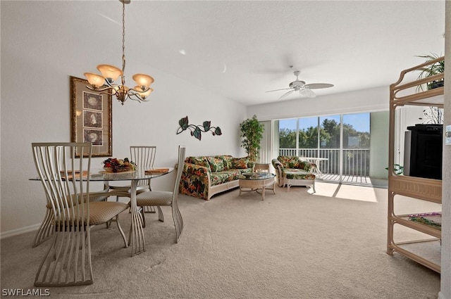 carpeted dining area featuring ceiling fan with notable chandelier