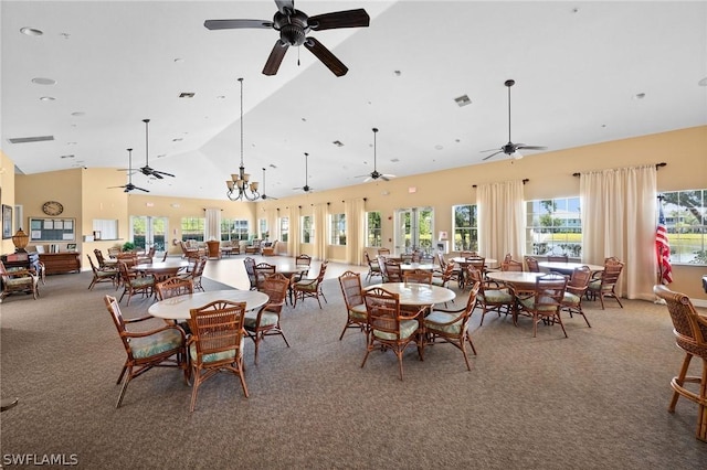 carpeted dining room featuring high vaulted ceiling, visible vents, and ceiling fan