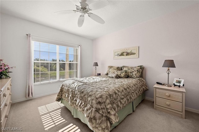 bedroom featuring light carpet, ceiling fan, and baseboards