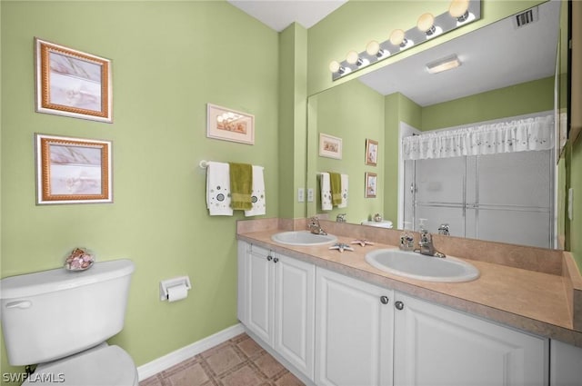 bathroom with double vanity, visible vents, toilet, and a sink