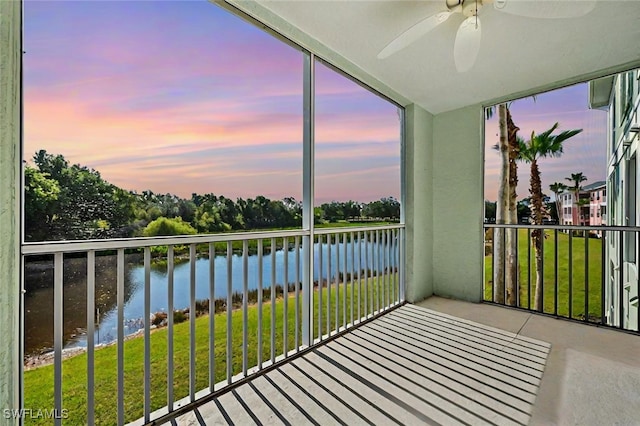 unfurnished sunroom with a water view and a ceiling fan