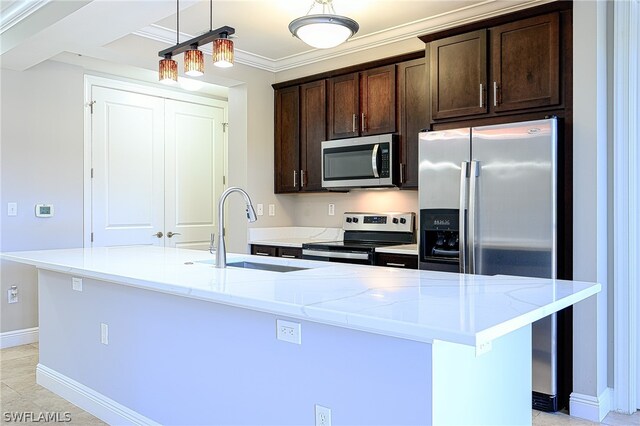 kitchen with appliances with stainless steel finishes, sink, a center island with sink, and light stone countertops