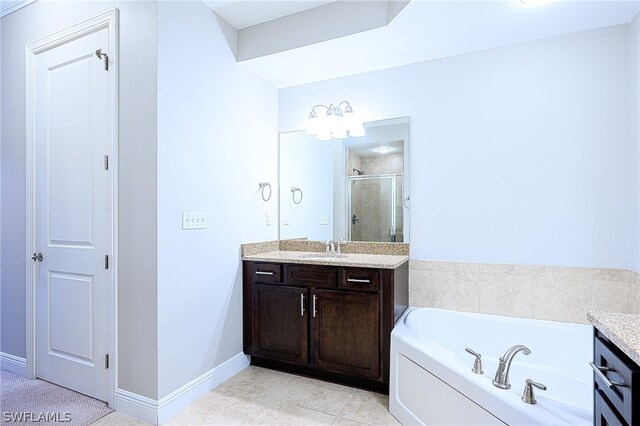 bathroom with tile flooring, vanity, and shower with separate bathtub