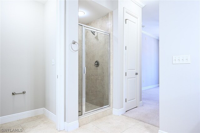 bathroom with tile flooring, walk in shower, and ornamental molding