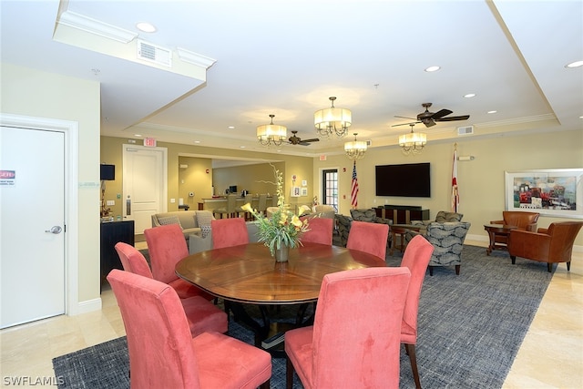 tiled dining area featuring ceiling fan with notable chandelier and a raised ceiling