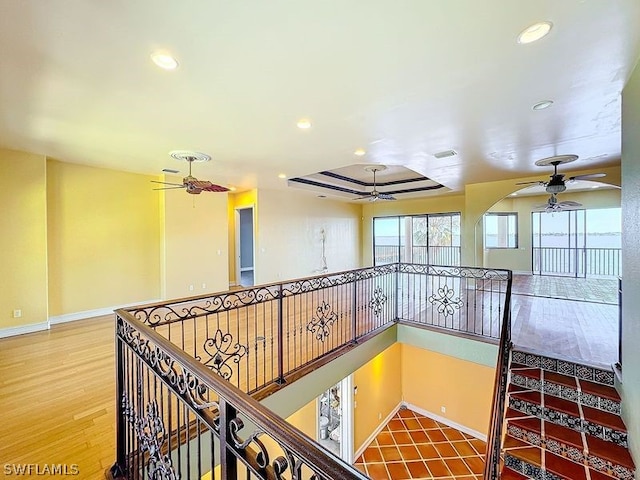 hallway featuring a raised ceiling and hardwood / wood-style flooring