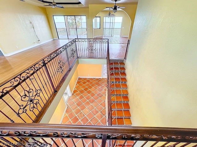 stairway featuring ceiling fan and hardwood / wood-style floors