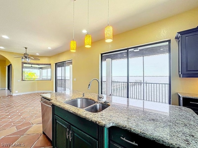 kitchen featuring decorative light fixtures, light stone countertops, stainless steel dishwasher, sink, and ceiling fan