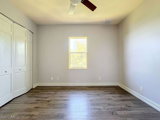 unfurnished bedroom featuring a closet, ceiling fan, and dark hardwood / wood-style floors