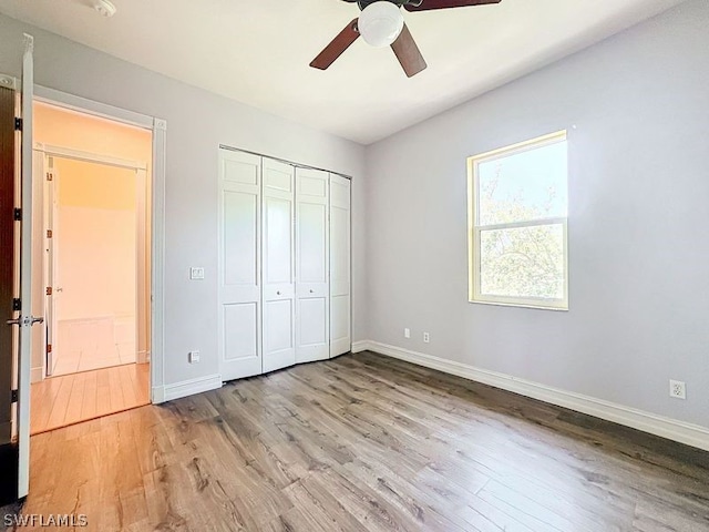 unfurnished bedroom with a closet, light hardwood / wood-style flooring, and ceiling fan