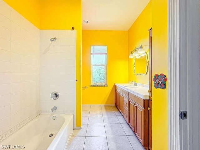 bathroom featuring tiled shower / bath, tile flooring, and vanity