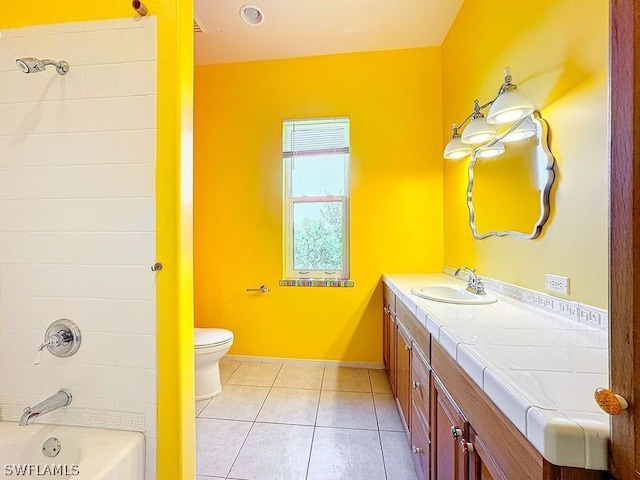 full bathroom with tiled shower / bath combo, toilet, tile flooring, and vanity