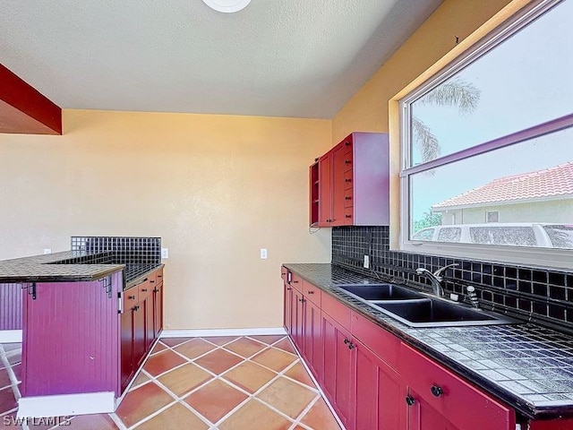 kitchen featuring backsplash, a kitchen breakfast bar, sink, and tile flooring