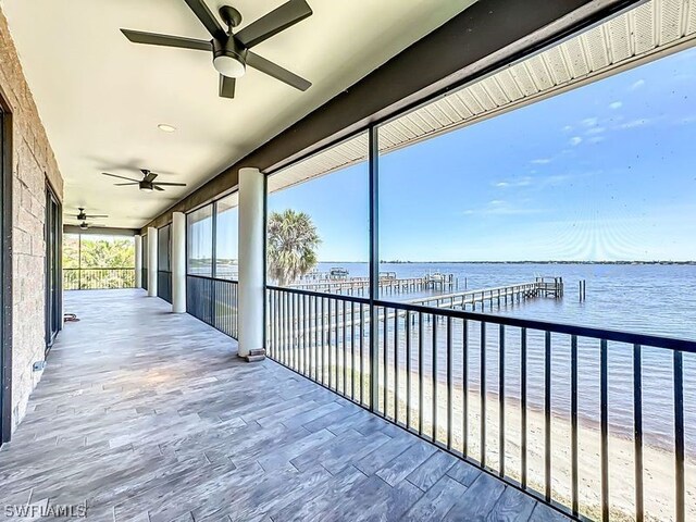 wooden deck featuring ceiling fan and a water view