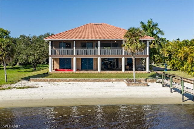 rear view of property with a balcony and a yard