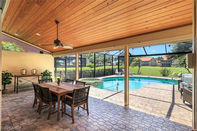 view of swimming pool featuring a patio, glass enclosure, an in ground hot tub, and ceiling fan