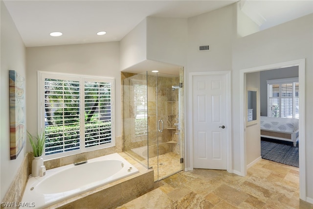 bathroom featuring vaulted ceiling, independent shower and bath, tile floors, and a wealth of natural light