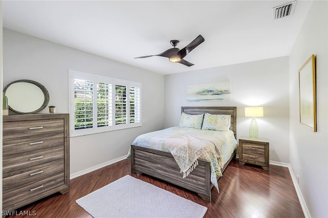 bedroom with dark hardwood / wood-style flooring and ceiling fan