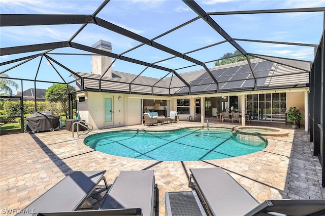 view of pool with a patio area, an in ground hot tub, area for grilling, and a lanai