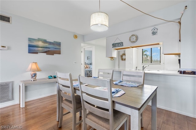 dining room with hardwood / wood-style flooring and sink