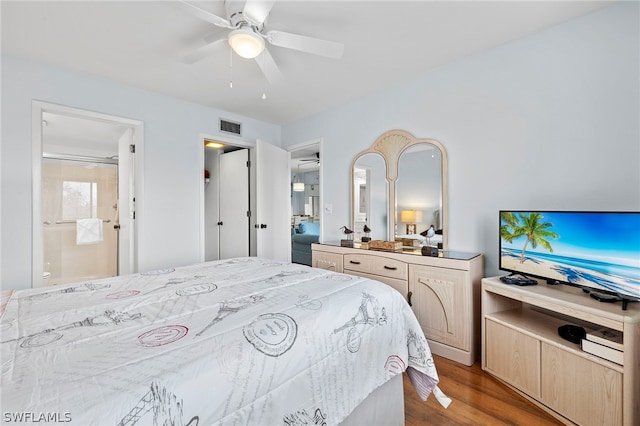 bedroom featuring ceiling fan, dark wood-type flooring, and ensuite bathroom