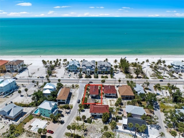 birds eye view of property featuring a water view and a beach view