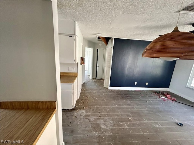 interior space with white cabinets and a textured ceiling