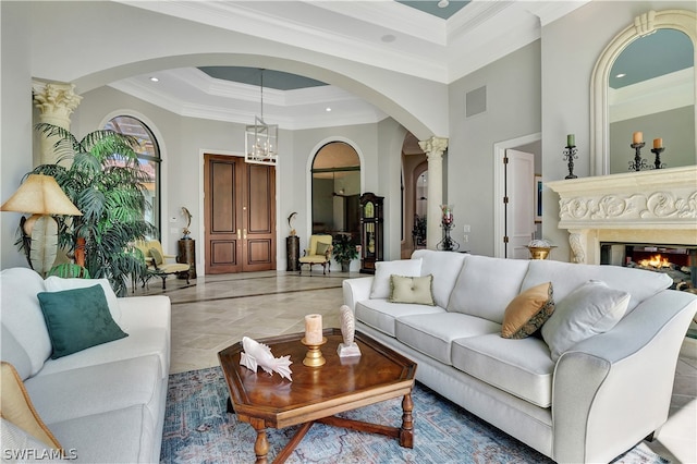 tiled living room featuring ornamental molding, a towering ceiling, a tray ceiling, and a premium fireplace