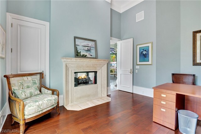 interior space with dark hardwood / wood-style flooring, a multi sided fireplace, and a high ceiling