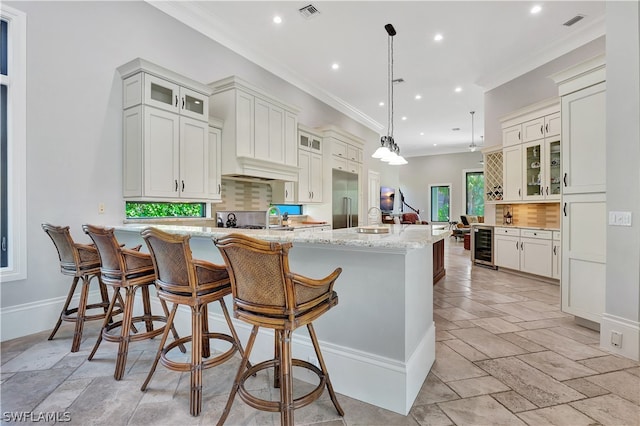 kitchen featuring tasteful backsplash, light tile floors, white cabinetry, and light stone countertops