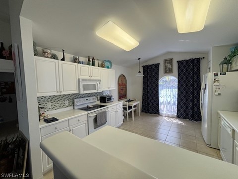 kitchen with decorative light fixtures, backsplash, white appliances, lofted ceiling, and light tile floors