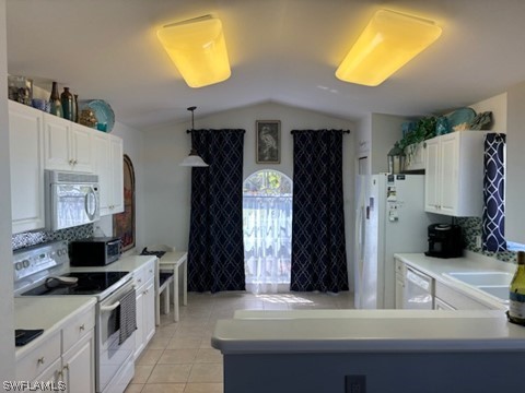 kitchen featuring pendant lighting, white appliances, light tile flooring, white cabinetry, and lofted ceiling