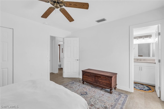 tiled bedroom with connected bathroom, ceiling fan, and sink