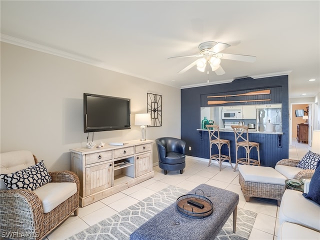 living room featuring ceiling fan, light tile floors, and ornamental molding