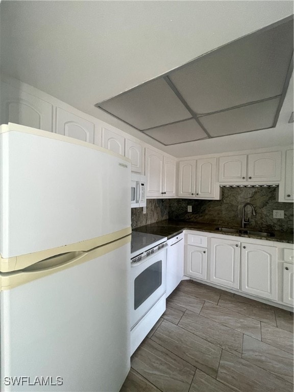 kitchen featuring tasteful backsplash, white appliances, white cabinets, and sink