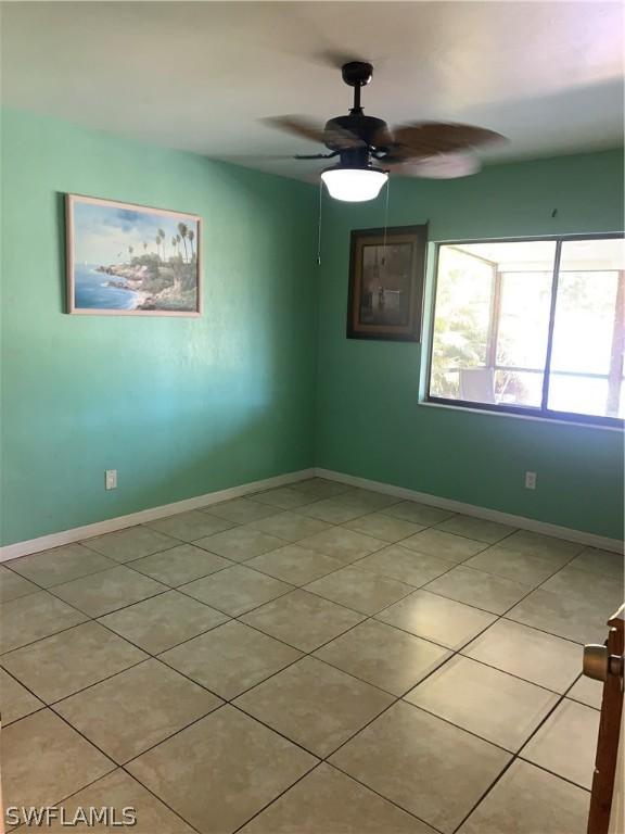 tiled empty room with ceiling fan