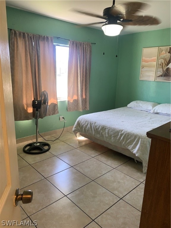 tiled bedroom featuring ceiling fan